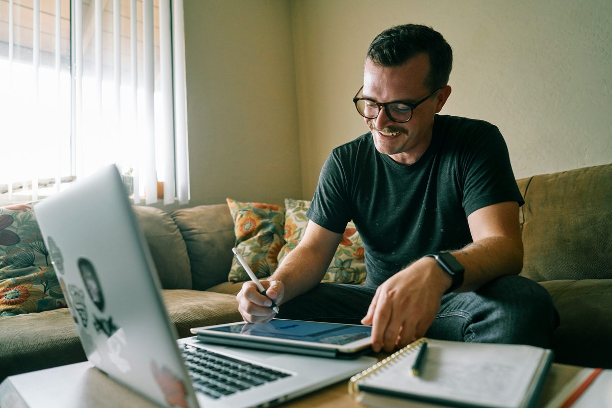 A sole trader doing his bookkeeping with a laptop and notebook